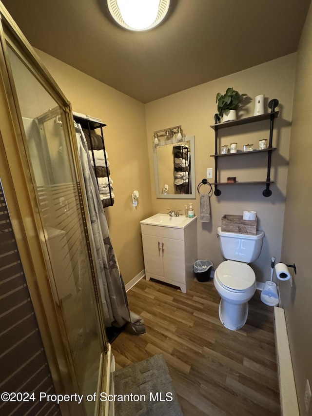 bathroom featuring a shower with curtain, toilet, wood-type flooring, and vanity