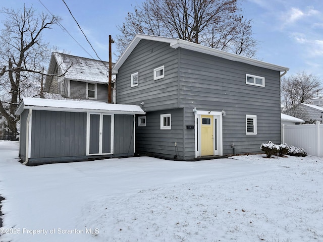 view of snow covered back of property