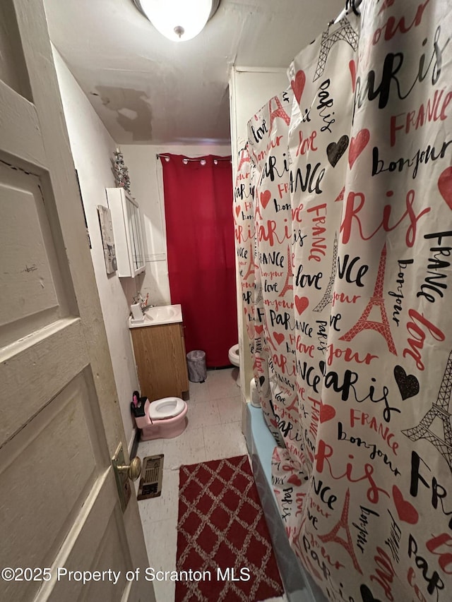 bathroom with tile patterned floors, toilet, shower / bath combo, and vanity