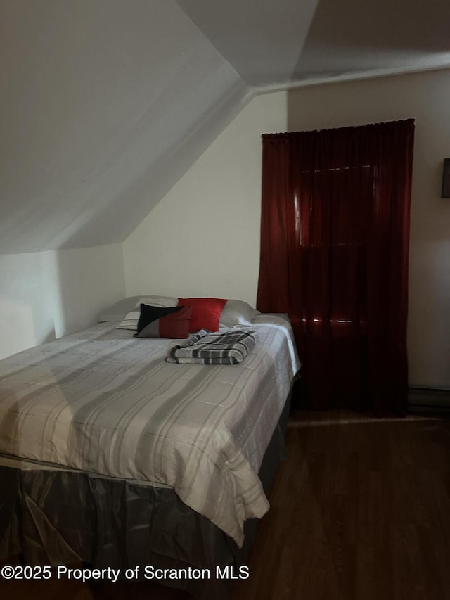 bedroom with lofted ceiling and wood finished floors