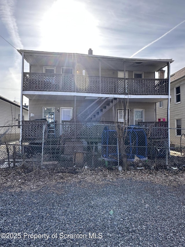 back of property with stairs and fence