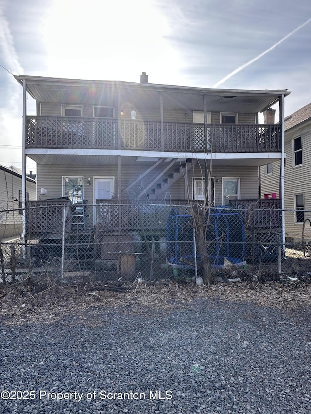 rear view of house with stairway and fence