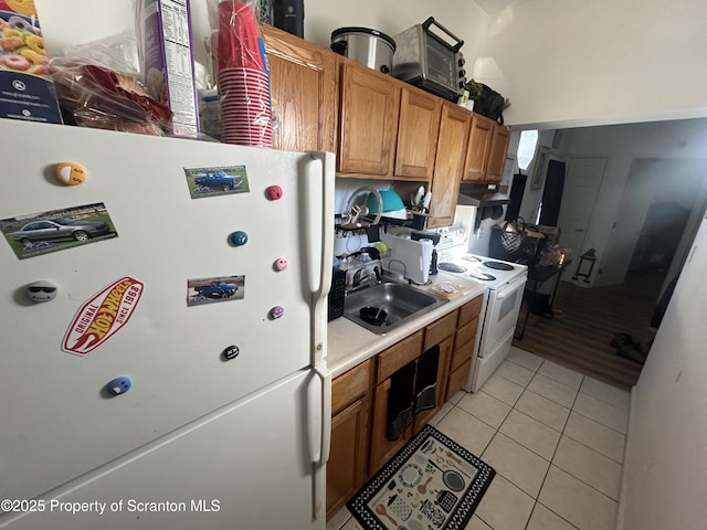 kitchen featuring sink, white appliances, and light tile patterned floors