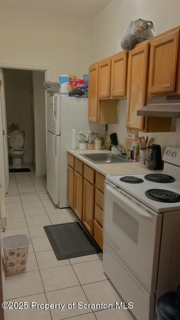 kitchen with sink, white electric range oven, and light tile patterned floors