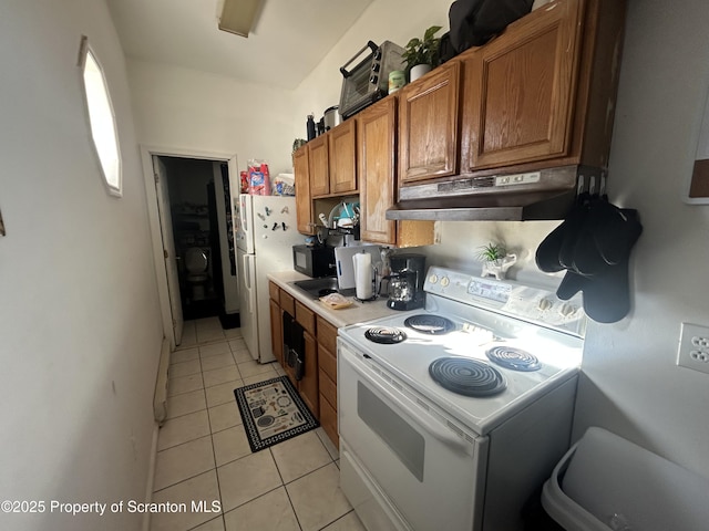 kitchen featuring white appliances and light tile patterned floors