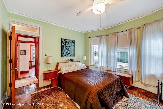 bedroom with hardwood / wood-style floors, ceiling fan, and crown molding