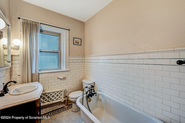 bathroom featuring a bath, tile patterned floors, toilet, vanity, and tile walls