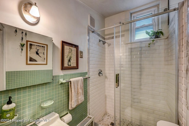 bathroom featuring toilet, tile walls, and walk in shower