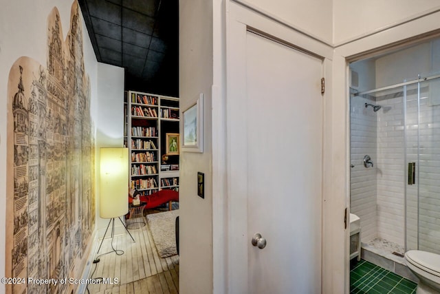 bathroom with toilet and a shower with shower door