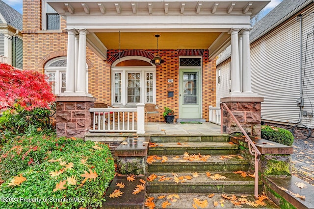 view of exterior entry with a porch