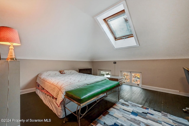 bedroom with lofted ceiling with skylight and dark wood-type flooring