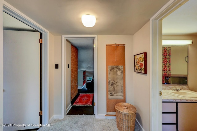 hallway featuring carpet flooring and sink