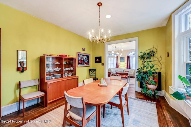 dining space with hardwood / wood-style flooring and an inviting chandelier