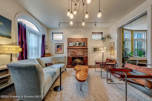 living room featuring wood-type flooring and a brick fireplace