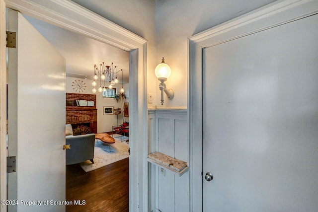 hallway featuring dark hardwood / wood-style floors and an inviting chandelier