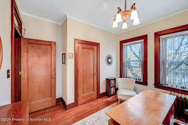 office with crown molding, a chandelier, and light hardwood / wood-style floors