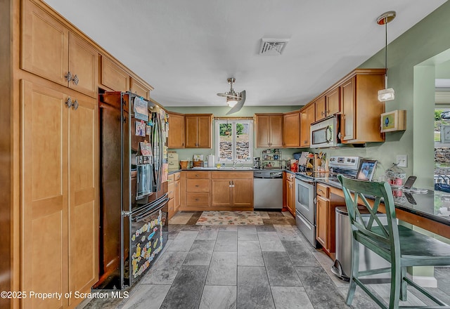 1017 Willow St Unit L14-15, Scranton, PA 18505 - kitchen with appliances with stainless steel finishes, dark countertops, brown cabinets, pendant lighting, and stone finish flooring