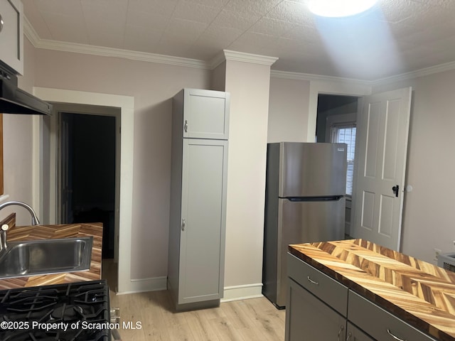 kitchen with wooden counters, stainless steel fridge, gray cabinetry, and sink