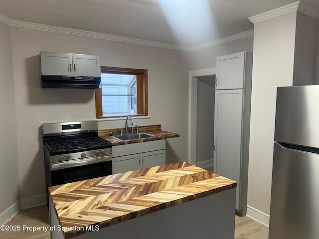 kitchen with stainless steel appliances, sink, butcher block counters, gray cabinets, and crown molding