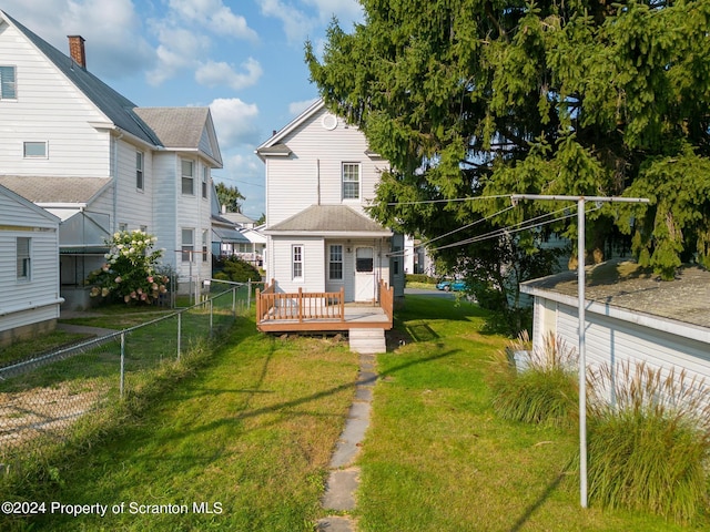 rear view of property with a deck and a yard