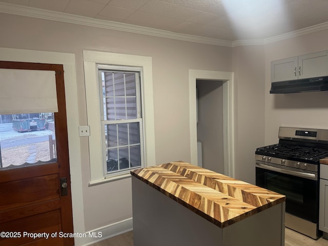 kitchen with ornamental molding, stainless steel gas range, wood counters, and a kitchen island