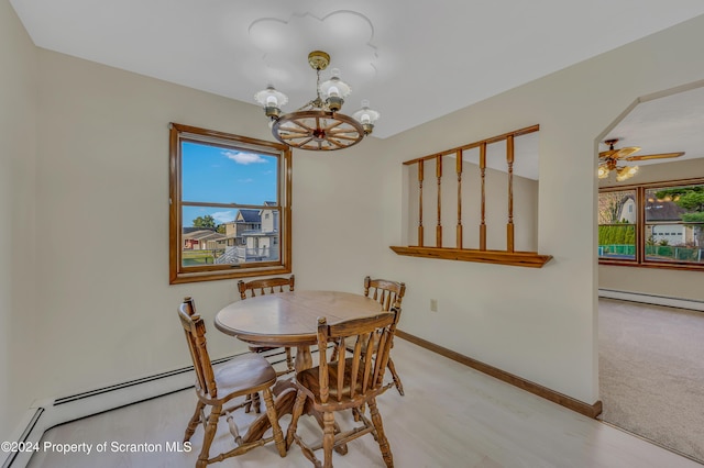 dining area with light hardwood / wood-style flooring, ceiling fan with notable chandelier, and a baseboard heating unit