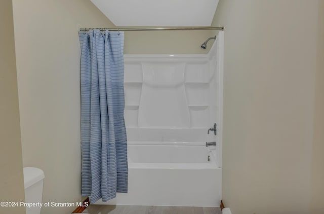 bathroom featuring shower / bath combo and toilet