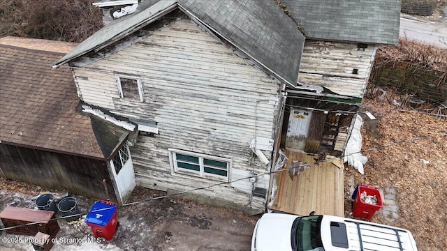 view of property exterior with a shingled roof