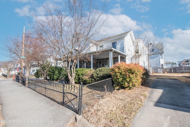 view of side of home featuring a gate and a fenced front yard