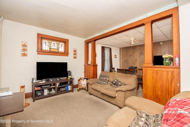 carpeted living area with a paneled ceiling