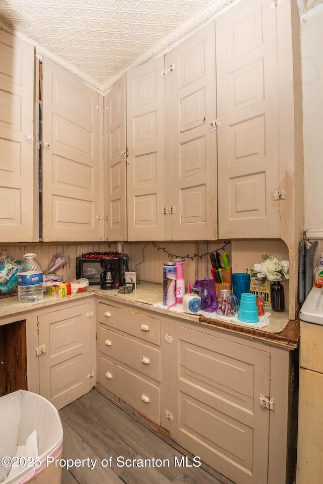 kitchen with an ornate ceiling, light countertops, and wood finished floors