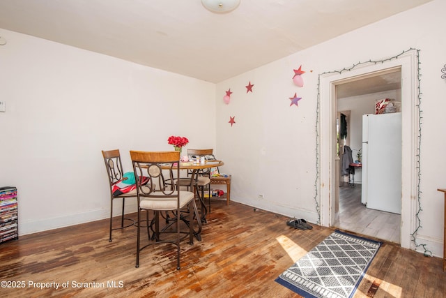 dining area with baseboards and wood-type flooring