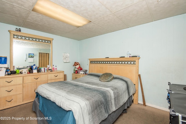 bedroom featuring carpet flooring, a paneled ceiling, and baseboards