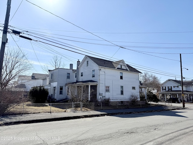 view of front of property featuring a residential view and fence