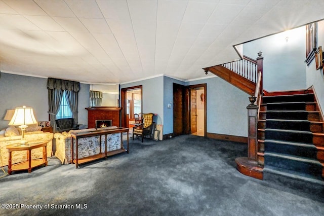 carpeted living room featuring crown molding and a fireplace