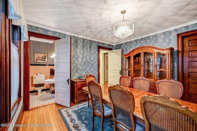 dining area featuring an inviting chandelier, crown molding, and hardwood / wood-style flooring