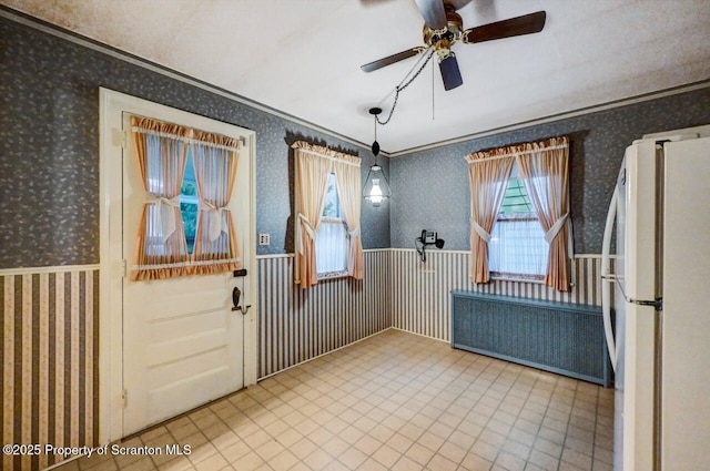 entryway with crown molding and ceiling fan