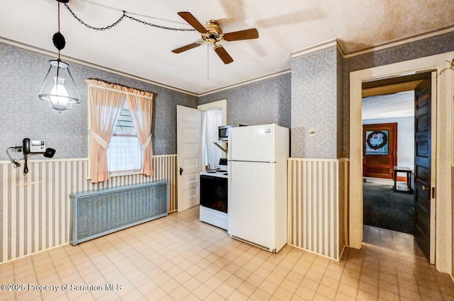 kitchen featuring hanging light fixtures, ornamental molding, ceiling fan, and white appliances