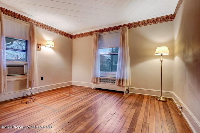 unfurnished room featuring wood-type flooring, ornamental molding, and cooling unit