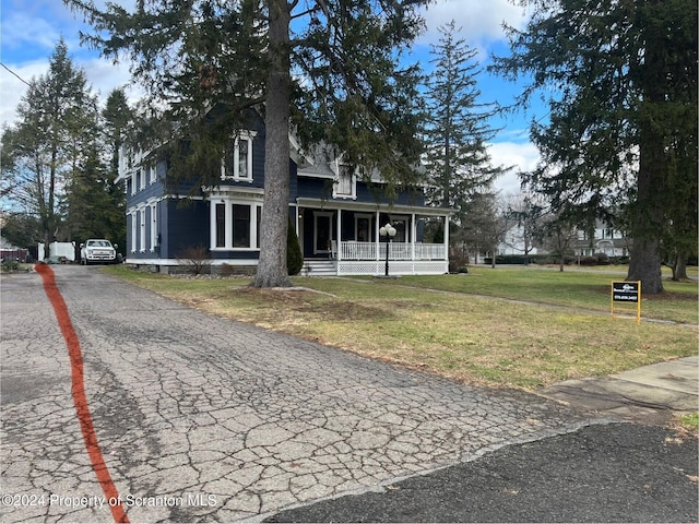 view of front of home featuring covered porch and a front yard