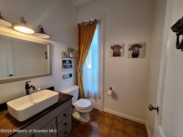 bathroom with tile patterned flooring, vanity, and toilet