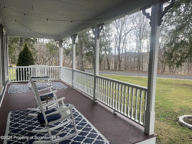 wooden terrace with a porch and a yard