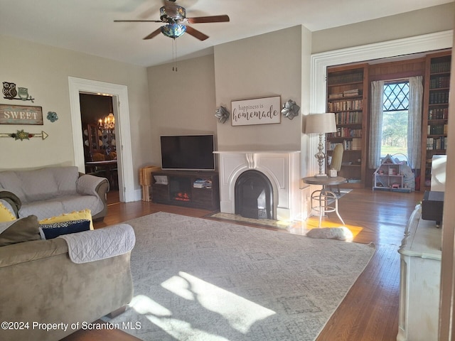 living room with dark hardwood / wood-style floors and ceiling fan with notable chandelier