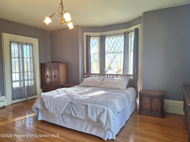 bedroom with hardwood / wood-style floors and a chandelier