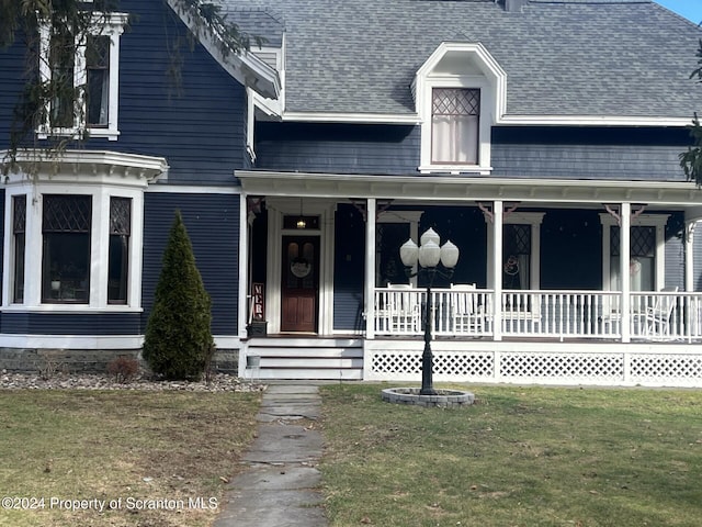 view of front of home with a porch and a front lawn