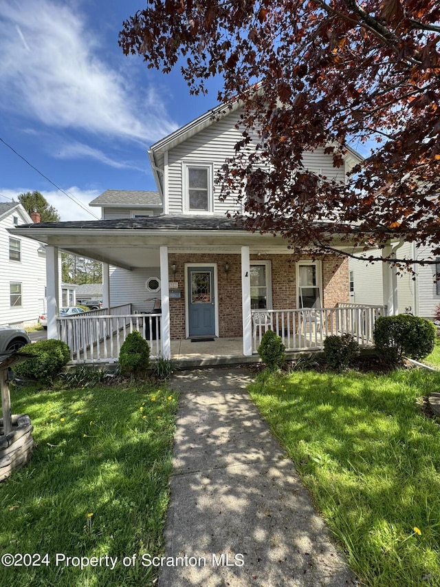 view of front of property with covered porch and a front yard