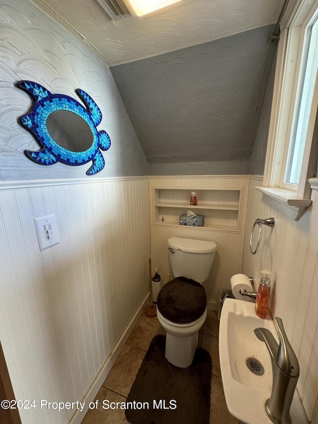 bathroom featuring sink, tile patterned flooring, lofted ceiling, and toilet