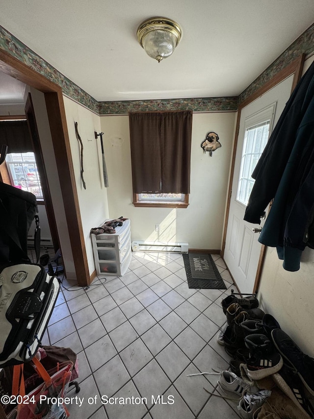 foyer entrance with light tile patterned floors and a baseboard radiator