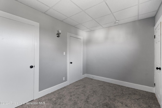 carpeted spare room with a drop ceiling