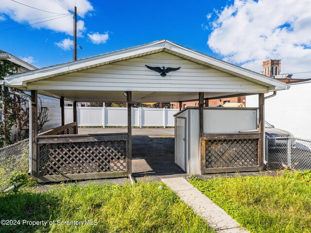 wooden deck with a shed and a carport